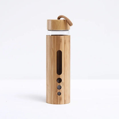 A bamboo glass water bottle with a window sleeve in the wide design displayed upright on a white background. — for Carpe Diem Dream