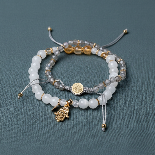A set of crystal bracelets featuring citrine, moonstone, and labradorite beads with gold accents and a hand of hamsa charm displayed on a muted teal background. — for Carpe Diem Dream