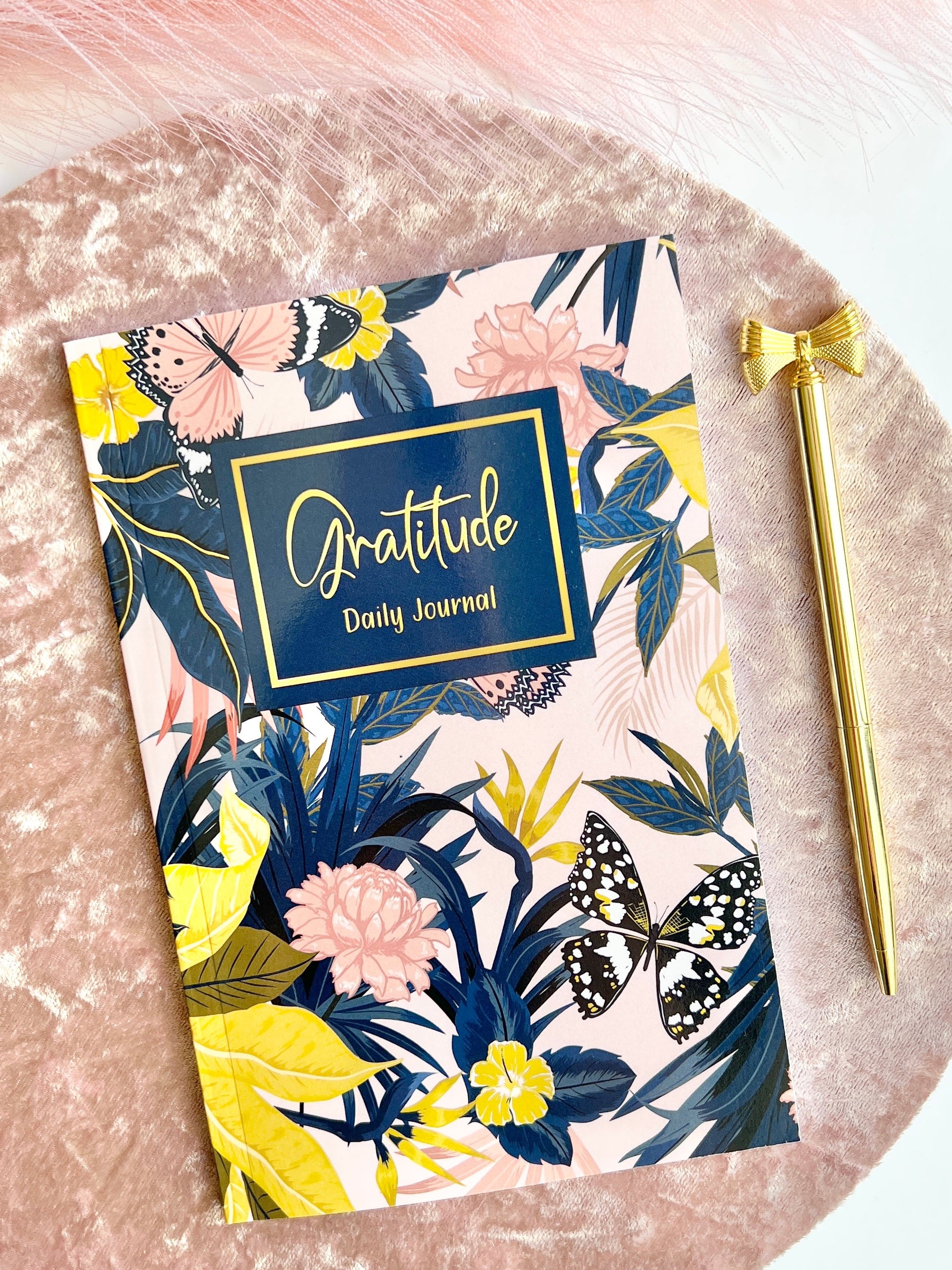 Floral Gratitude Daily Journal in glossy softcover format displayed on a blush velvet surface with a gold pen beside it — for Carpe Diem Dream