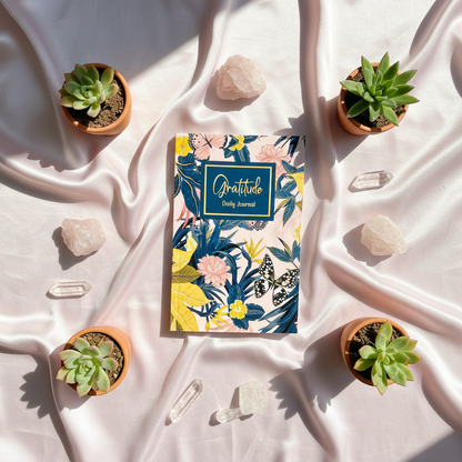 Gratitude Daily Journal displayed on white draped fabric surrounded by small succulents and clear crystals in soft natural light — for Carpe Diem Dream