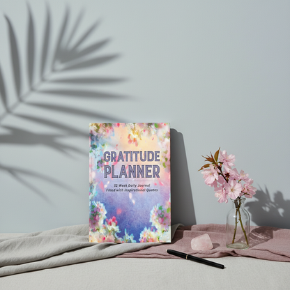 Gratitude Planner hardcover displayed with soft botanical styling, blush florals, rose quartz, and mauve linen accents on a cool neutral backdrop. — for Carpe Diem Dream
