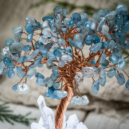 Close-up of aquamarine crystal chips and twisted copper branches on the angel tree lamp with soft greenery in the background. — for Carpe Diem Dream