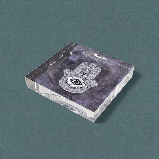 A square acrylic Hamsa catchall dish with a purple marbled design displayed on a muted teal textured background with soft directional lighting. — for Carpe Diem Dream