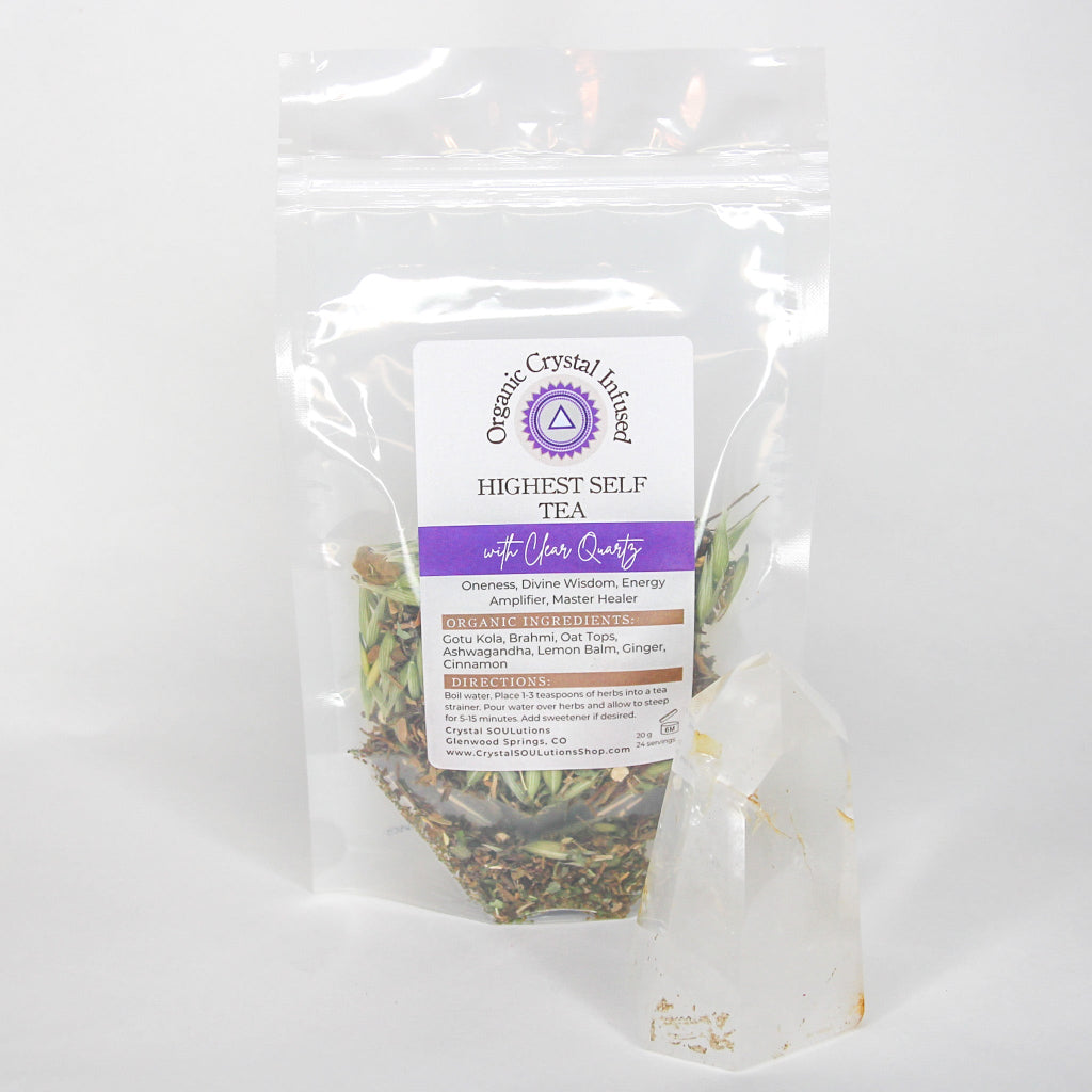 Highest Self Tea – Organic Crystal Infused 20g loose-leaf herbal tea with Clear Quartz crystal energy, displayed beside a polished Clear Quartz point with the herbal tea blend visible through the clear pouch on a clean white background. — for Carpe Diem Dream