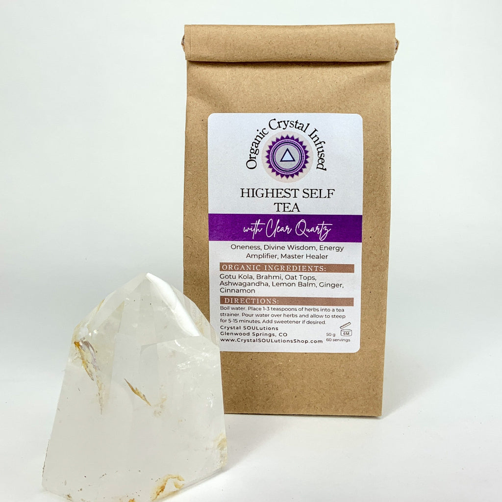 Highest Self Tea – Organic Crystal Infused 50g loose-leaf herbal tea with Clear Quartz crystal energy, displayed beside a polished Clear Quartz point on a clean white background. — for Carpe Diem Dream
