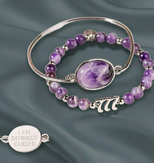 Purple amethyst crystal and silver bracelet set displayed on a muted teal silk backdrop, showcasing the 777 charm and engraved pendant — for Carpe Diem Dream