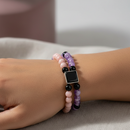 Feminine power healing bracelet in amethyst, pink opal, and onyx displayed on a wrist in a detailed close-up with soft diffused lighting — for Carpe Diem Dream