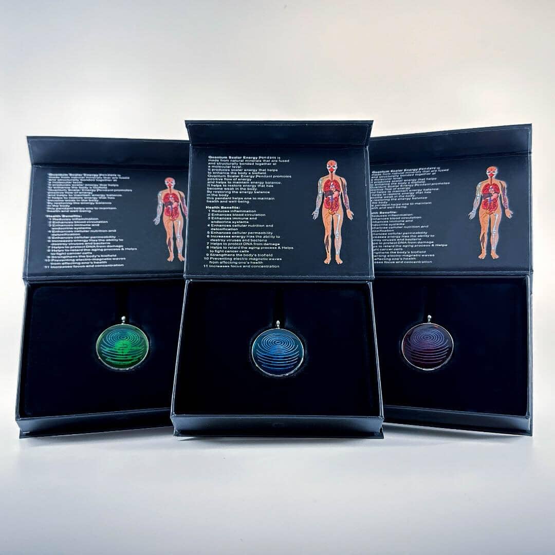 Three ion glass defense pendants in green, blue, and red displayed inside open presentation boxes with printed inserts on a white background. — for Carpe Diem Dream