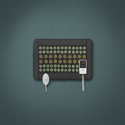 Jade and tourmaline far infrared heating pad with digital controller displayed on a muted teal textured background. — for Carpe Diem Dream