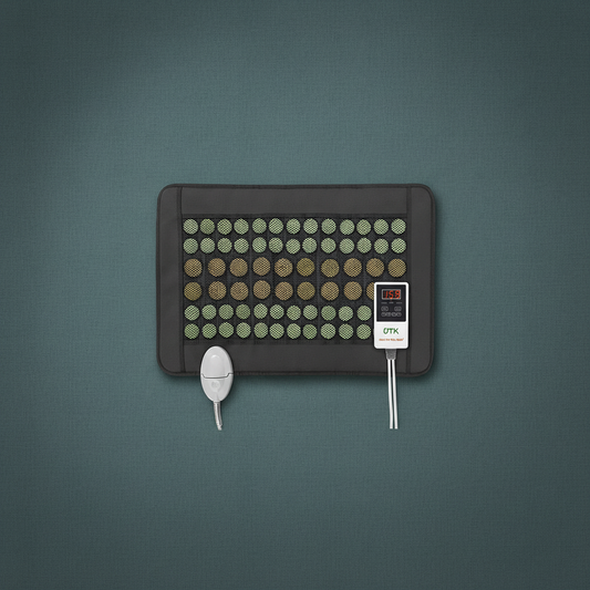Jade and tourmaline far infrared heating pad with digital controller displayed on a muted teal textured background. — for Carpe Diem Dream