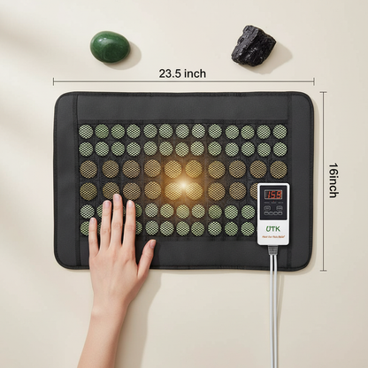 Jade and tourmaline far infrared heating pad with hand showing scale and 23.5 by 16 inch dimensions on a neutral background. — for Carpe Diem Dream