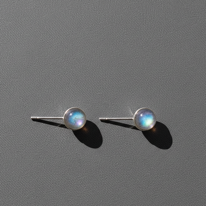 Silver labradorite stud earrings resting on a softly textured studio background. — for Carpe Diem Dream