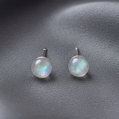 Silver labradorite stud earrings resting on a softly draped silk background. — for Carpe Die
