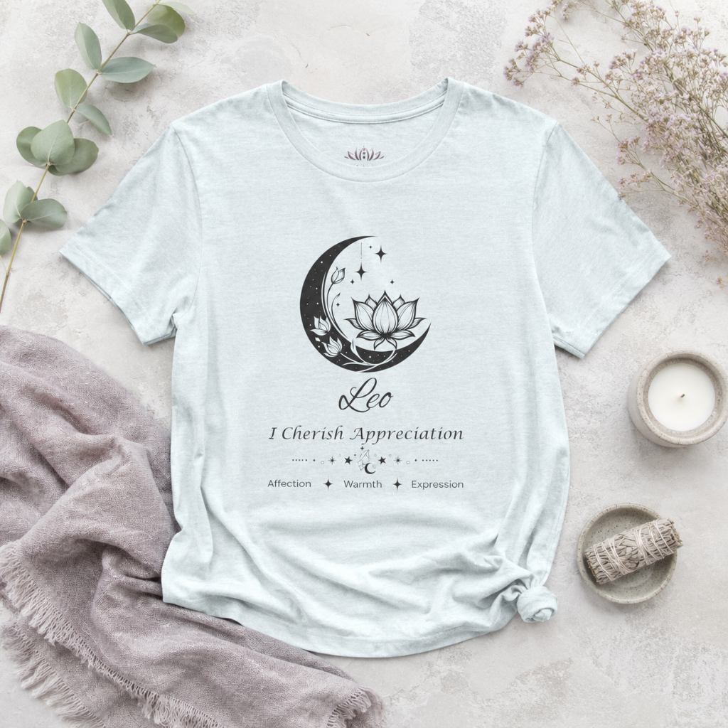 Leo Moon I Cherish Appreciation zodiac T-shirt in Heather Ice Blue with black moon-inspired lotus, floral, and celestial artwork and Affection, Warmth, Expression text, styled in a cool-toned studio botanical flat lay. — for Carpe Diem Dream