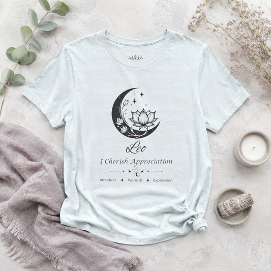 Leo Moon I Cherish Appreciation zodiac T-shirt in Heather Ice Blue with black moon-inspired lotus, floral, and celestial artwork and Affection, Warmth, Expression text, styled in a cool-toned studio botanical flat lay. — for Carpe Diem Dream