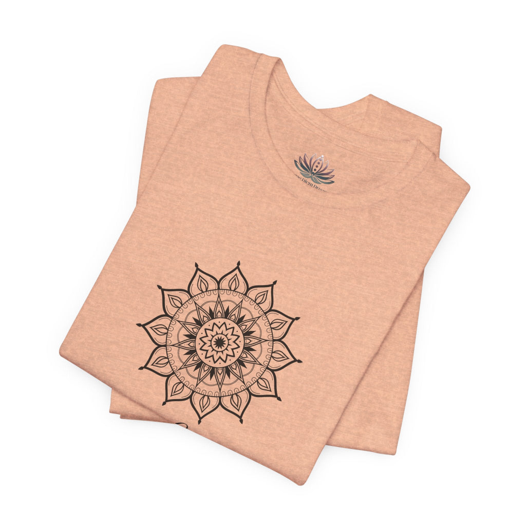 Leo Sun I Will zodiac T-shirt in heather peach with black sun-inspired mandala artwork, shown folded with Carpe Diem Dream neck label in a supplier mockup. — for Carpe Diem Dream