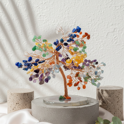 Feng Shui chakra tree posed on stone props with draped fabric against a textured white wall. — for Carpe Diem Dream