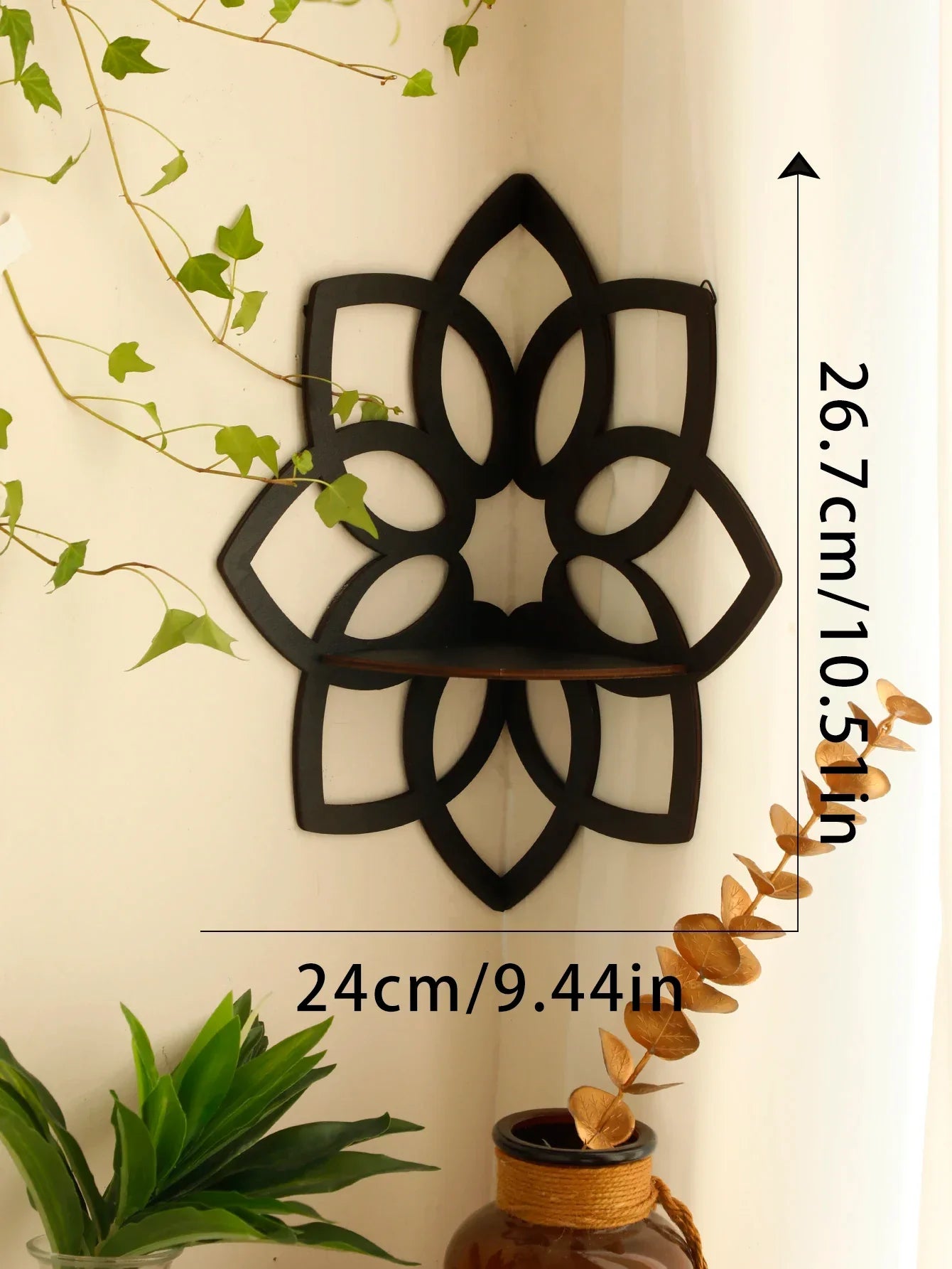 A black lotus-shaped wall shelf mounted in a corner with visible dimensions labeled approximately 24 cm wide and 26.7 cm tall with plants in the scene. — for Carpe Diem Dream