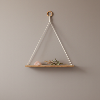 A macrame wall shelf with a wooden platform and cotton rope hanging design styled with a crystal and dried botanical on a soft neutral background. — for Carpe Diem Dream
