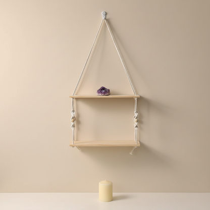 A two-tier macrame wall shelf with natural wood platforms and cotton rope design styled with a small crystal and candle on a soft neutral wall, creating a calm altar-like display. — for Carpe Diem Dream