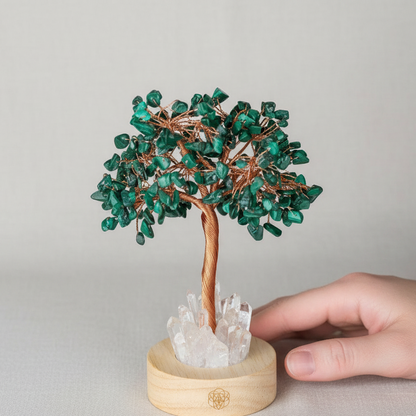A malachite crystal tree lamp with copper wire branches and a clear quartz base shown with a hand for size reference against a neutral background. — for Carpe Diem Dream