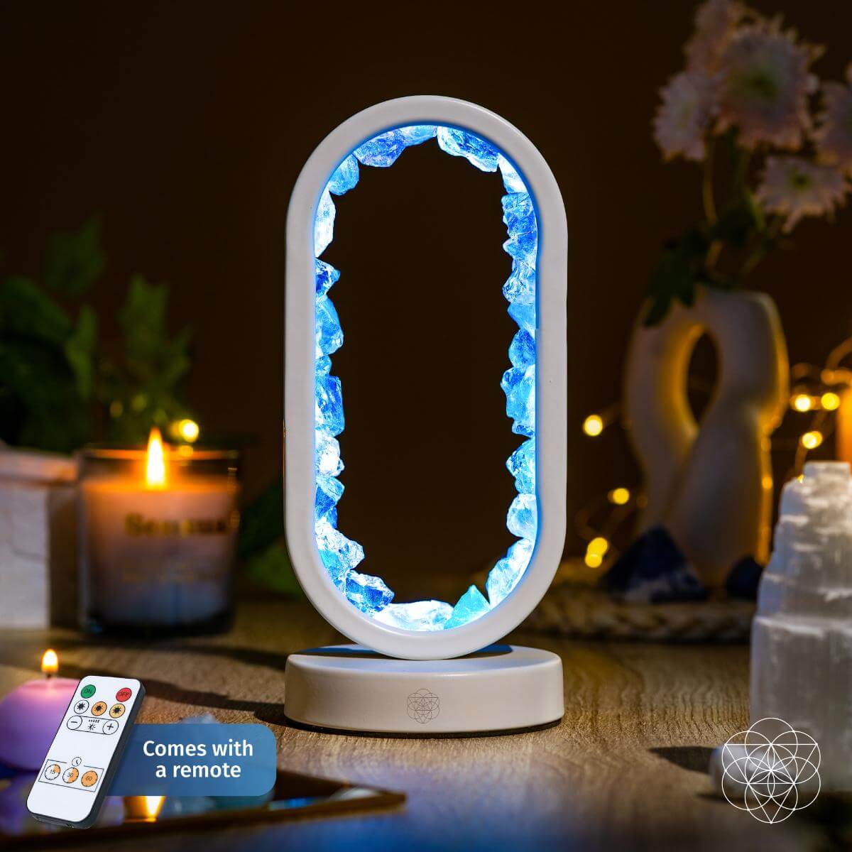 Decorative lamp with blue light on a table with a candle and remote control.