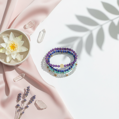 A four-bracelet manifestation set featuring amazonite, labradorite, amethyst, and lapis lazuli beads arranged in a studio botanical setting with soft fabric, crystals, and a lotus bowl. — for Carpe Diem Dream