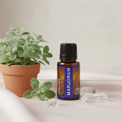 Amber glass bottle of Marjoram Essential Oil styled beside fresh green marjoram leaves and clear crystal stones on a neutral surface in soft natural light. — for Carpe Diem Dream