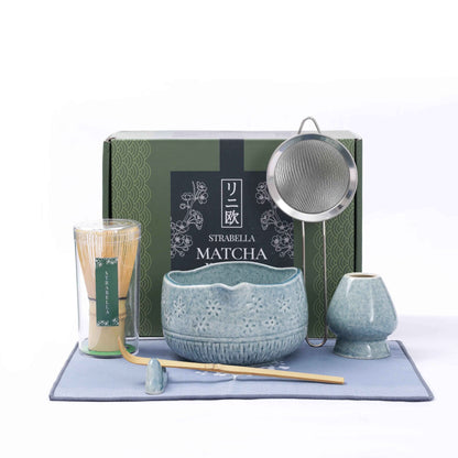 Blue Matcha Ritual Set with bamboo whisk, ceramic tea bowl, whisk holder, scoop, strainer, and gift box displayed on a matching blue tea towel. — for Carpe Diem Dream
