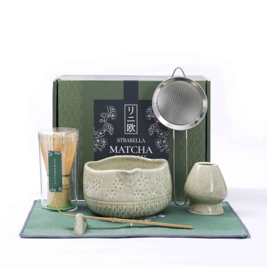 Green Matcha Ritual Set with bamboo whisk, ceramic tea bowl, whisk holder, scoop, strainer, and gift box displayed on a matching green tea towel. — for Carpe Diem Dream