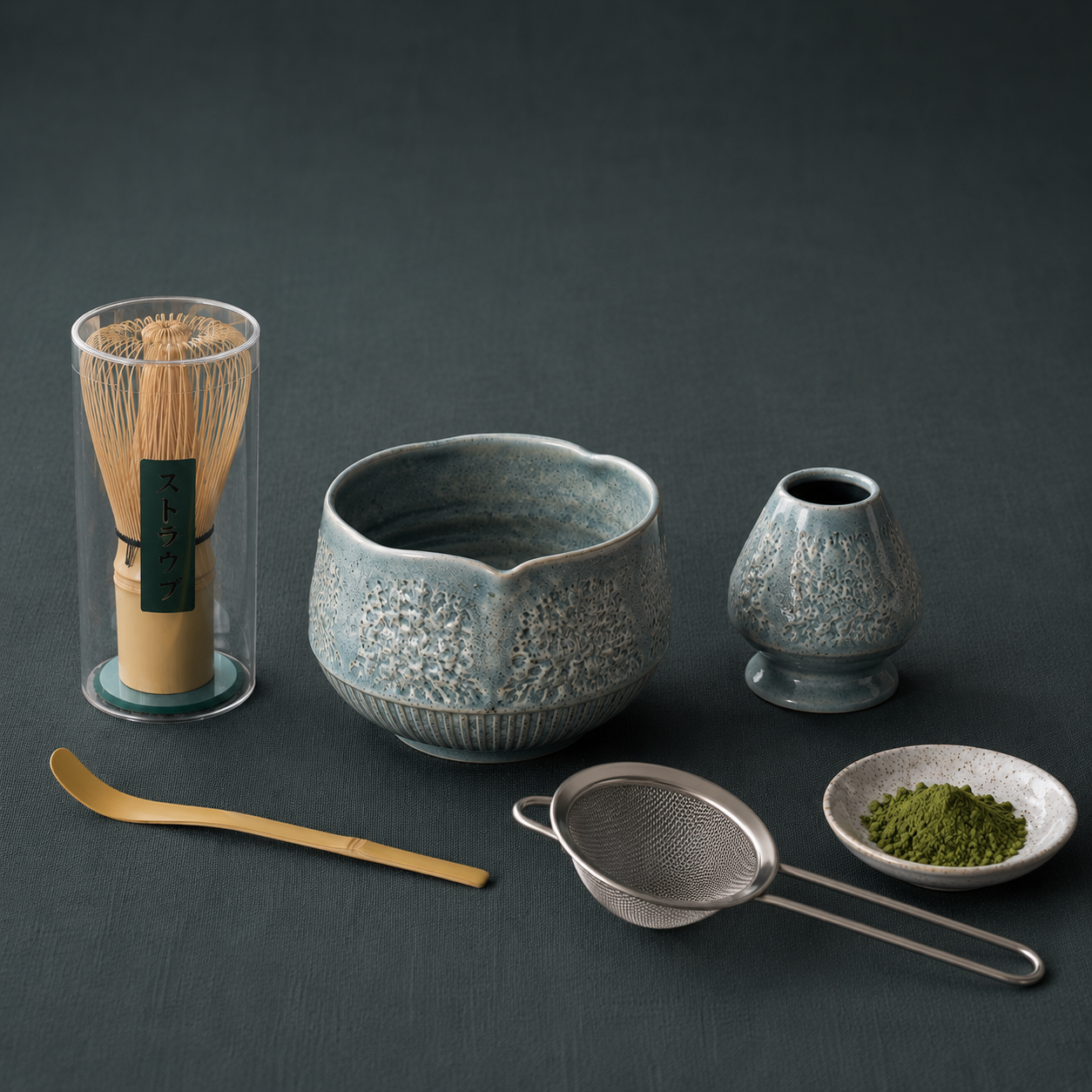Matcha Ritual Set featuring a bamboo whisk, ceramic tea bowl, whisk holder, scoop, strainer, and matcha accessories arranged on #374F59 textured linen with soft shadows and cool diffused lighting. — for Carpe Diem Dream