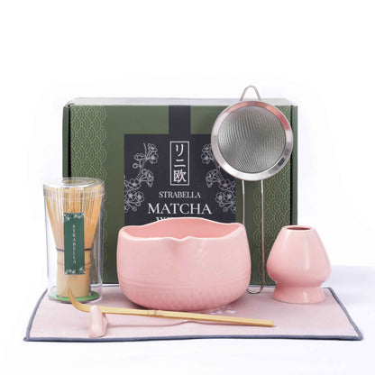 Pink Matcha Ritual Set with bamboo whisk, ceramic tea bowl, whisk holder, scoop, strainer, and gift box displayed on a matching pink tea towel. — for Carpe Diem Dream