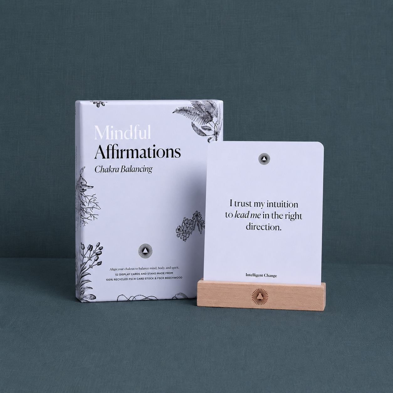 Mindful Affirmations for Chakra Balancing card deck displayed on a textured #374F59 teal linen surface with cool diffused studio lighting, showcasing the deck and affirmation card with true colors and premium craftsmanship. — for Carpe Diem Dream