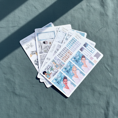 Four 4x6 mindfulness and self care planner sticker sheets fanned out on a textured teal fabric surface with soft natural light — for Carpe Diem Dream