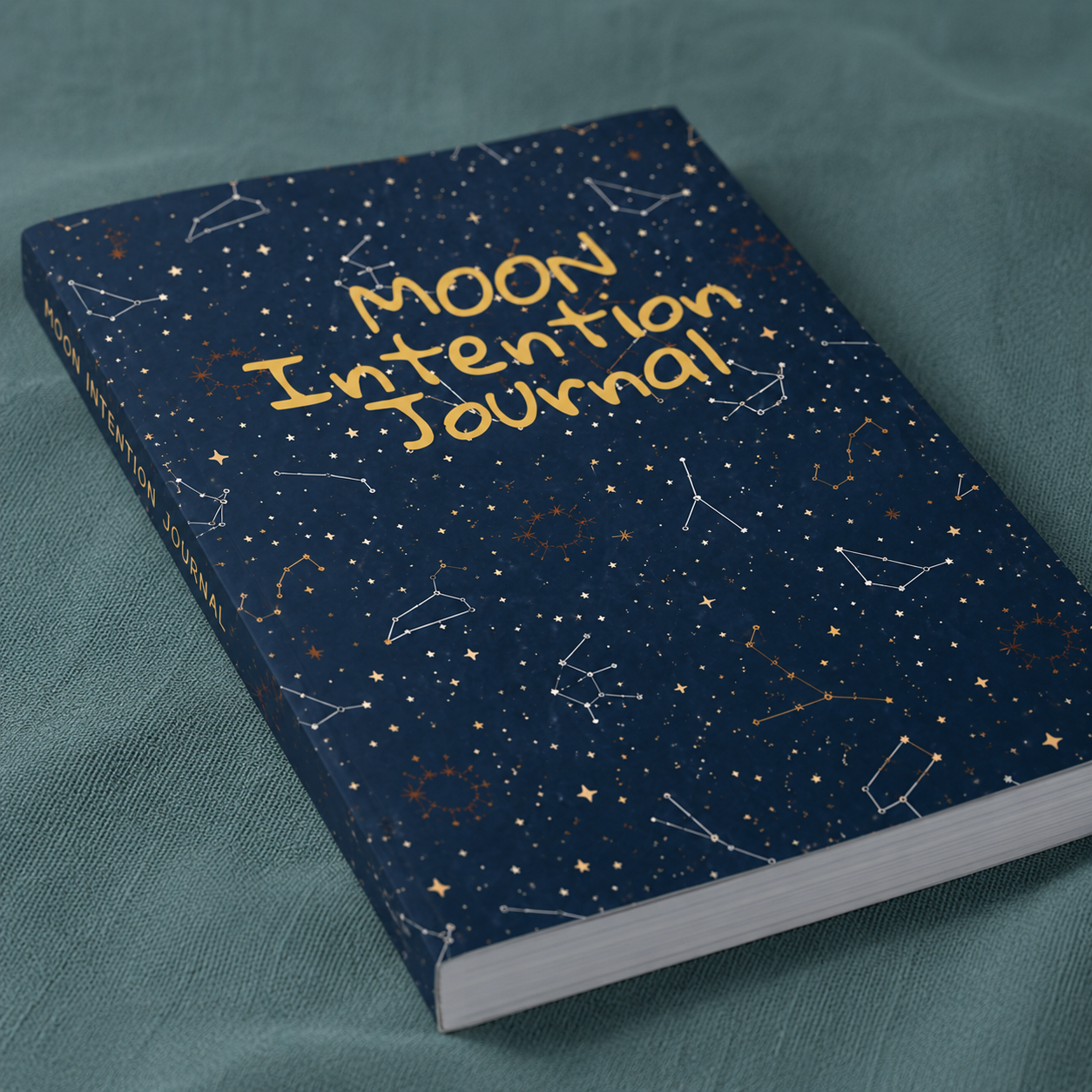 Close-up view of the Moon Intention Journal showing celestial artwork, constellation details, moon symbolism, and paperback binding. — for Carpe Diem Dream.