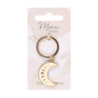 Moon Phase Celestial Keychain featuring an enameled gold crescent moon charm with lunar phase design, displayed on a white branded backing card under soft neutral lighting for Carpe Diem Dream.