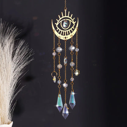 Moon Eyes variant of the gold moon phase crystal sun catcher featuring an eye motif with hanging faceted crystals displayed against a dark background. — for Carpe Diem Dream