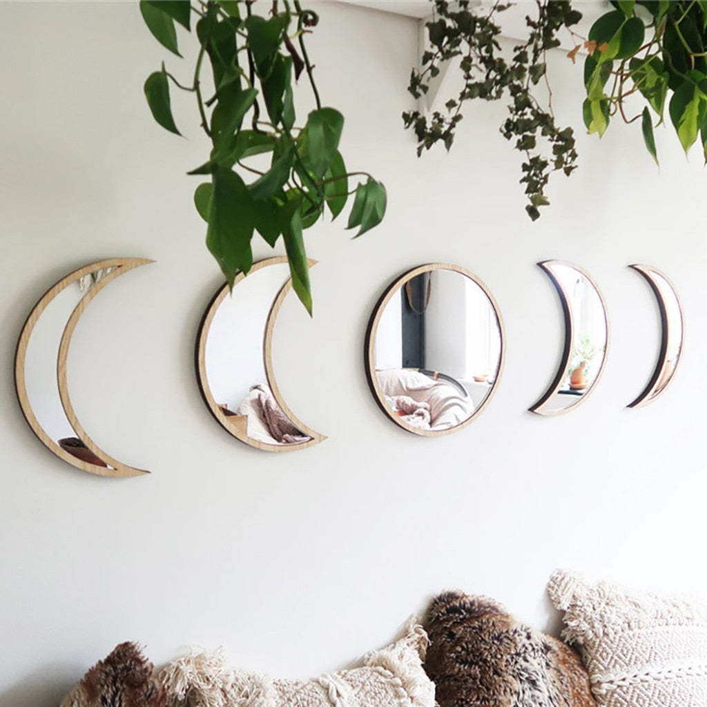 Beige five-piece moon phase wall mirror set displayed above a bed with textured pillows and greenery hanging overhead in a soft boho bedroom setting. — for Carpe Diem Dream