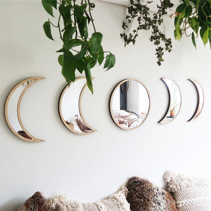 Beige five-piece moon phase wall mirror set displayed above a bed with textured pillows and greenery hanging overhead in a soft boho bedroom setting. — for Carpe Diem Dream