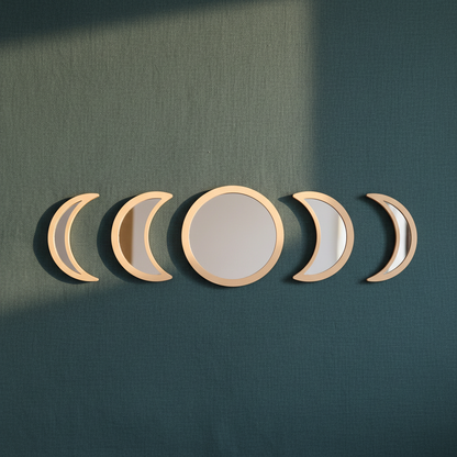 Five-piece moon phase wall mirror set with beige wood frames displayed on a deep teal textured wall with soft natural light. — for Carpe Diem Dream
