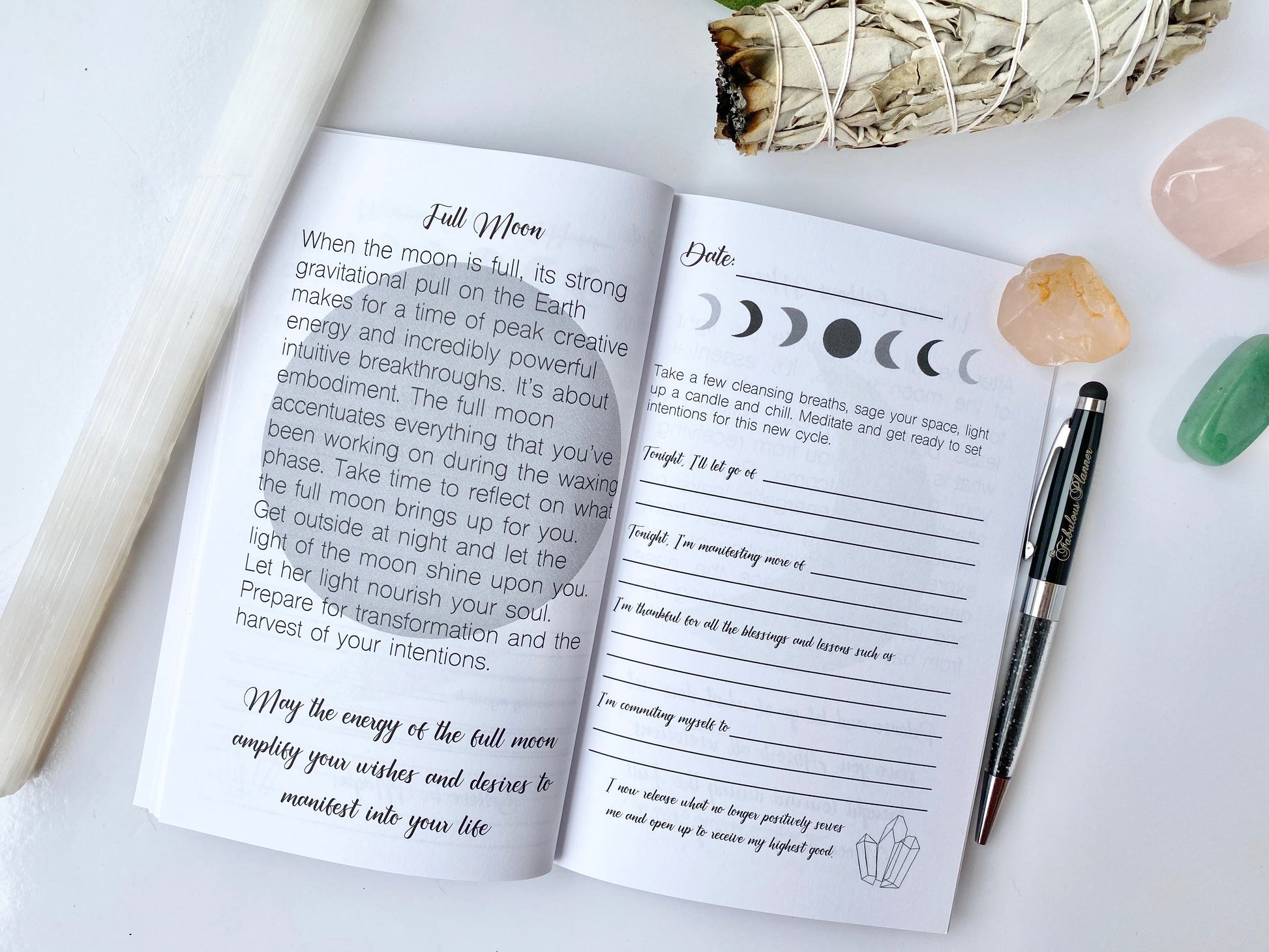 Interior spread of Moon Rituals & Manifestation Journal showing Full Moon reflection page with lunar phase graphics, guided prompts, and lined writing sections beside a pen and crystals on a white background — for Carpe Diem Dream