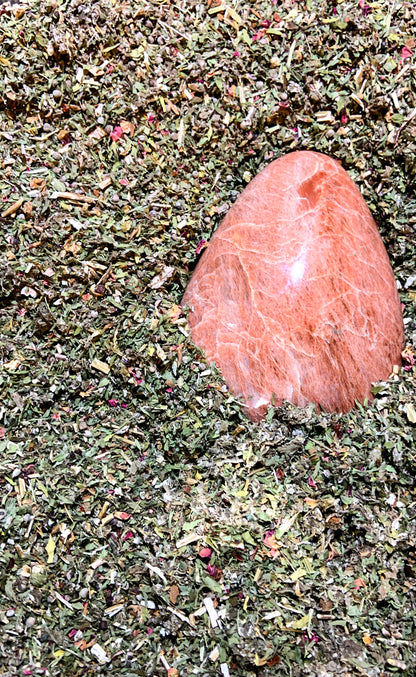 Organic loose-leaf herbal tea ingredients with polished Moonstone crystal for Moon Time Ease Tea – Organic Crystal-Infused Tea. — for Carpe Diem Dream