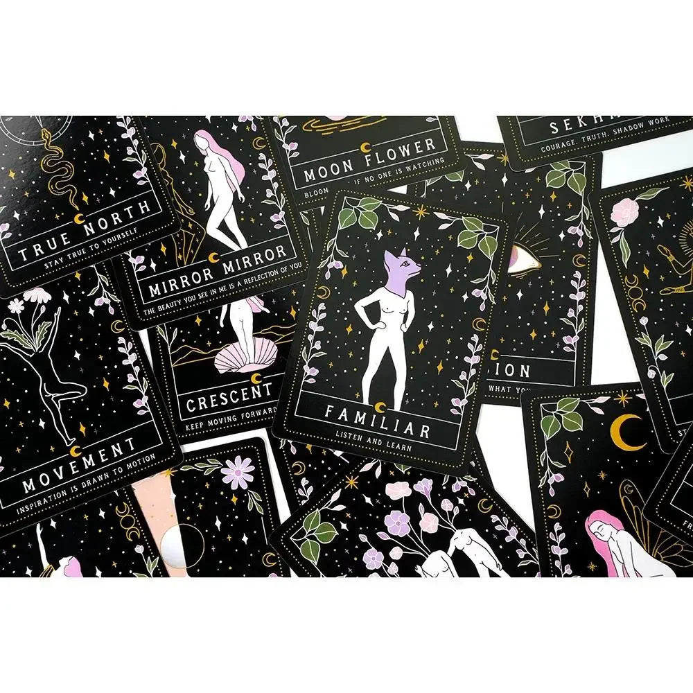 A close-up spread of Moon Witch Oracle cards featuring celestial, floral, and symbolic illustrations arranged across a dark background. — for Carpe Diem Dream