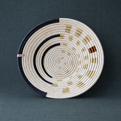 Moonrise Wall Basket handwoven decorative wall basket with natural, navy, and golden woven pattern on a dark teal textured linen backdrop. — for Carpe Diem Dream