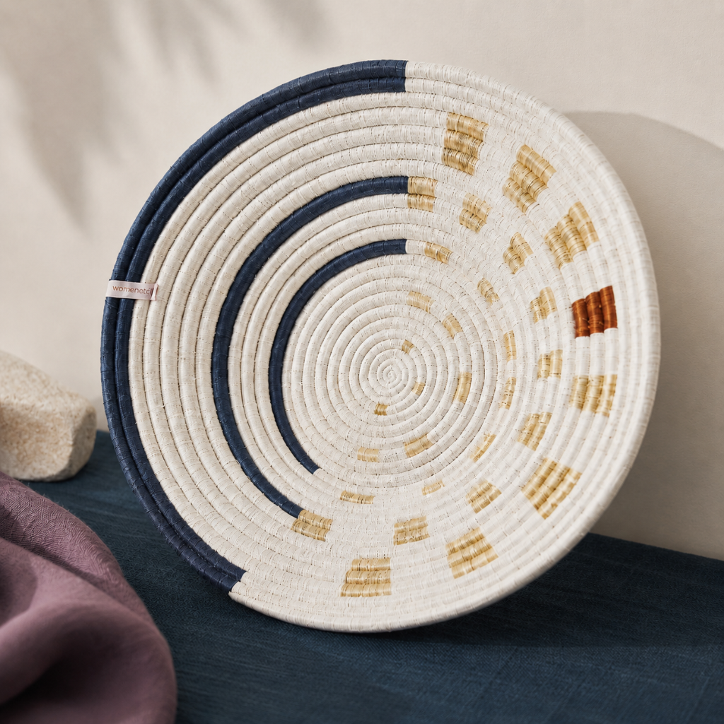 Close-up of Moonrise Wall Basket showing handwoven natural grass texture, navy and golden thread detail, shallow bowl shape, and artisan stitching. — for Carpe Diem Dream