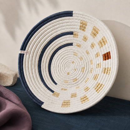 Close-up of Moonrise Wall Basket showing handwoven natural grass texture, navy and golden thread detail, shallow bowl shape, and artisan stitching. — for Carpe Diem Dream