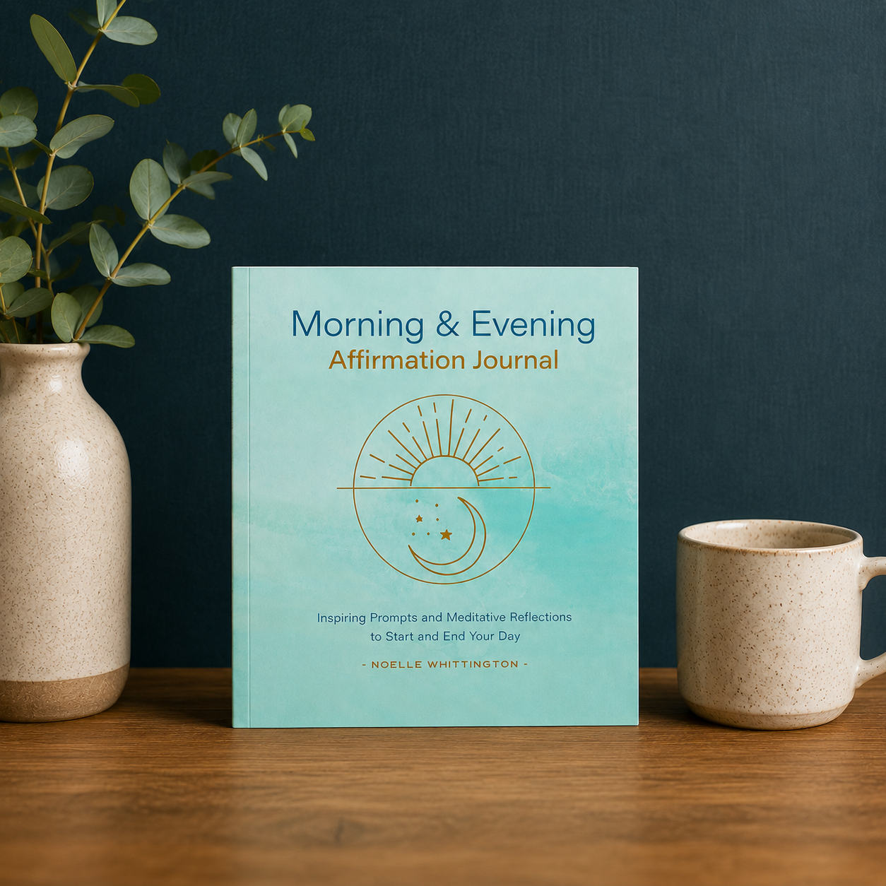Morning & Evening Affirmation Journal paperback by Noelle Whittington displayed on a tabletop beside a ceramic mug and botanical arrangement, providing a realistic visual reference for the journal’s true 8 x 8 inch size and daily mindfulness practice — for Carpe Diem Dream
