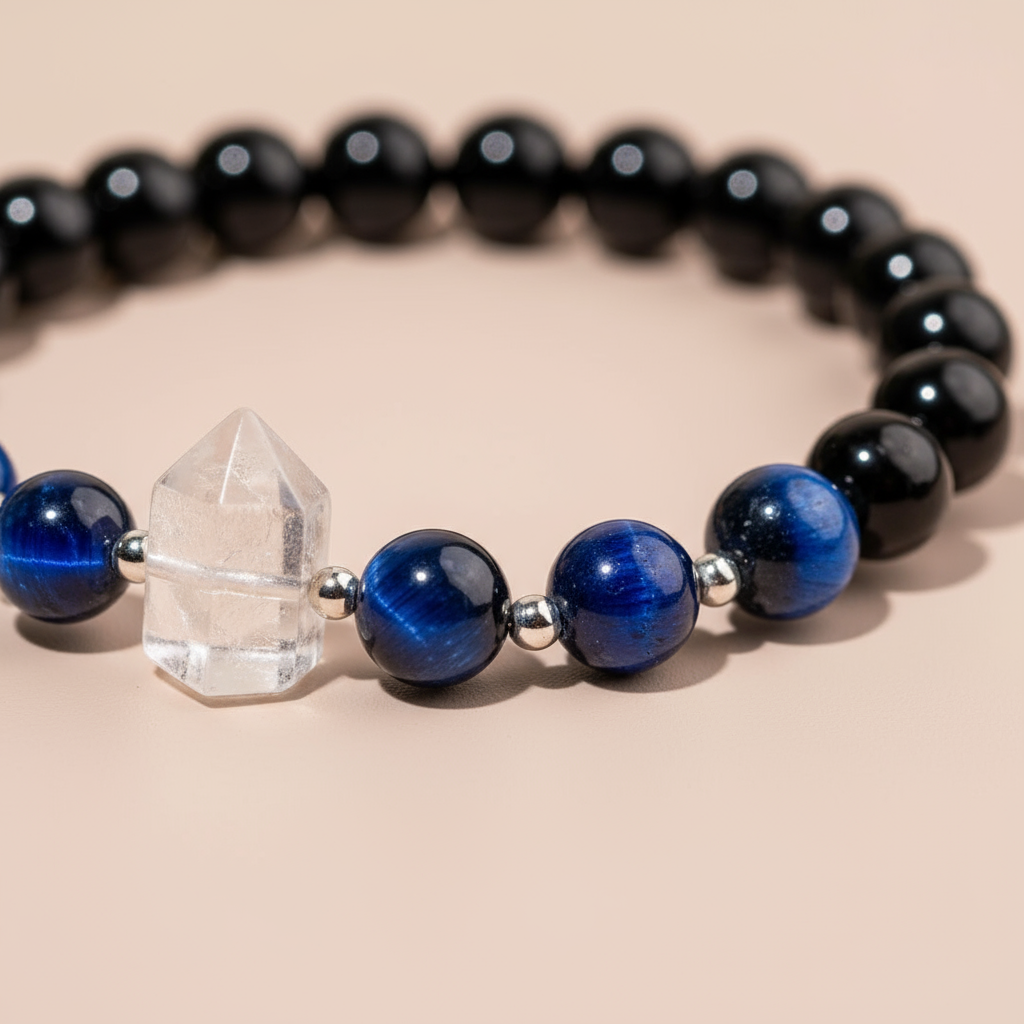 Close-up of Negativity Filter gemstone bracelet showing Clear Quartz point and Blue Tiger’s Eye beads on soft blush background. — for Carpe Diem Dream