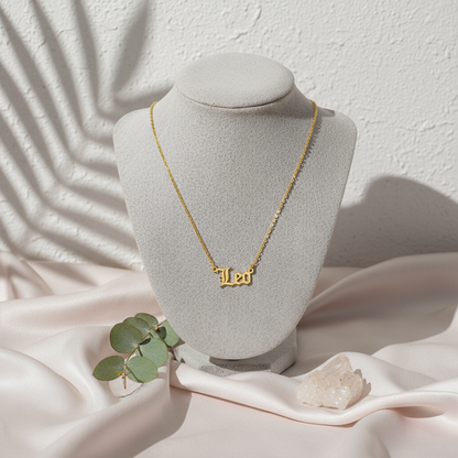 Gold Old English Zodiac Leo Necklace with astrology lettering on botanical pink silk travertine background for Carpe Diem Dream