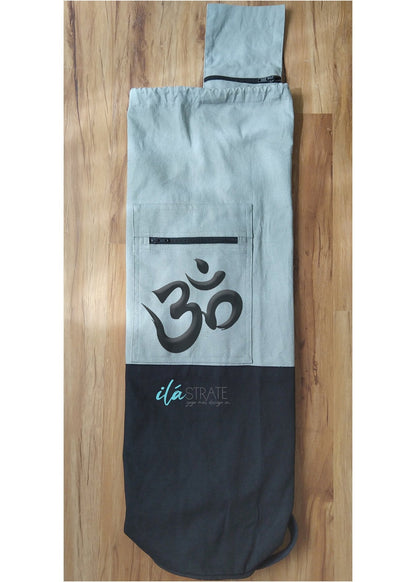 Grey cotton dual tone Om yoga mat bag displayed flat on natural wood flooring. — for Carpe Diem Dream